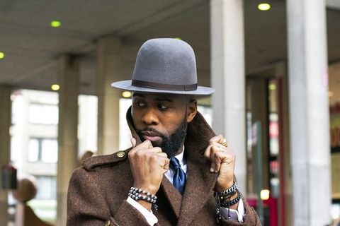 身穿棕色上衣、戴灰色帽子的男子