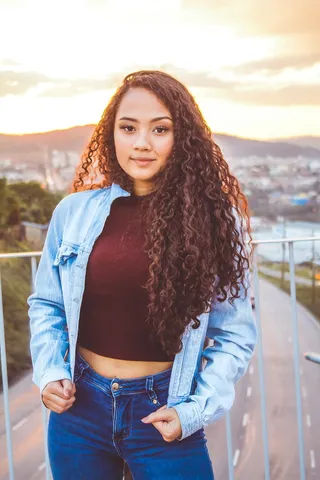 站在栏杆附近时，一名女子拿着她的牛仔夹克