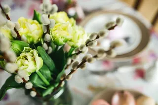 复活节餐桌上有可爱的粉色装饰、鲜花、柳絮和鸡蛋