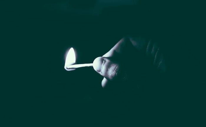 灰度照片，人物，手持，点燃，火柴棒，火，黑暗，夜晚
