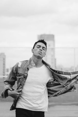 男子闭着眼睛脱下牛仔夹克的灰度照片