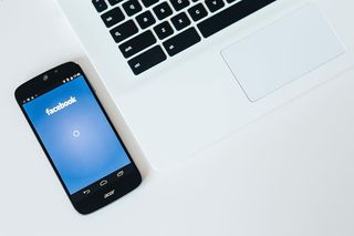 带智能手机和耳机的白色笔记本电脑