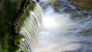 盛夏，工厂上游的卡萨德瀑布落在宾夕法尼亚州特拉华镇丁曼渡口的乔治·W·奇尔德游乐场。