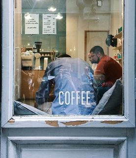 一群男人坐在靠近窗户的房间里的沙发上