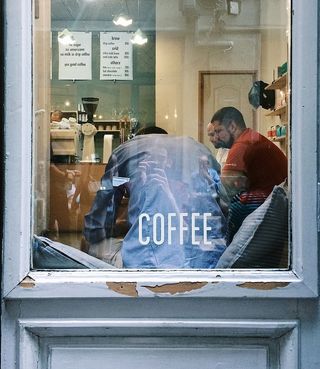 一群男人坐在靠近窗户的房间里的沙发上