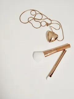 金色化妆刷和项链的照片 金色化妆刷和项链的照片