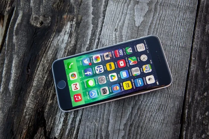 在木质纹理背景上拍摄的iPhone 6移动智能手机的高分辨率照片