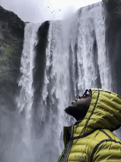 瀑布附近穿着泡泡连帽衫夹克的男子照片 瀑布附近穿着泡泡连帽衫夹克的男子照片