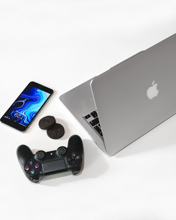 黑色索尼游戏板旁的银色MacBook