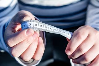 白色卷尺，卷尺，包裹，手，手指，手指间，滞留，卷尺卷起