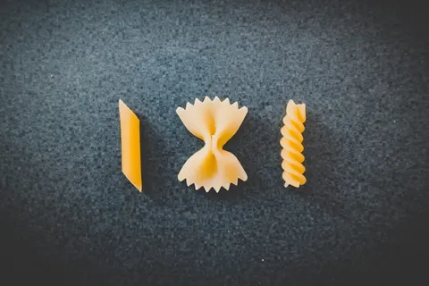 黑色表面上有三块不同的通心粉 黑色表面上有三块不同的通心粉