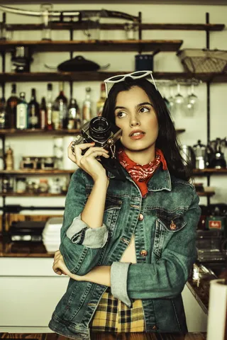 手持黑色单反相机的女性