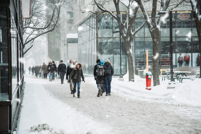 人们在建筑物附近的雪地上行走