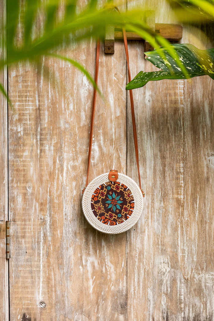 棕色木板上的米色和红色花朵十字形圆形包