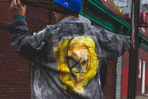 男子面朝后，右手拿着金属柱