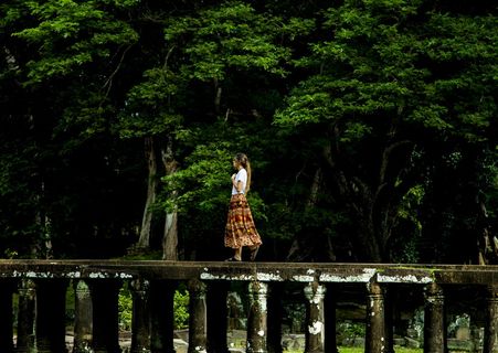 走在树环绕的桥上的女人