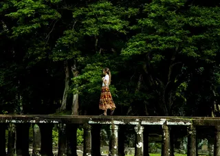 走在树环绕的桥上的女人