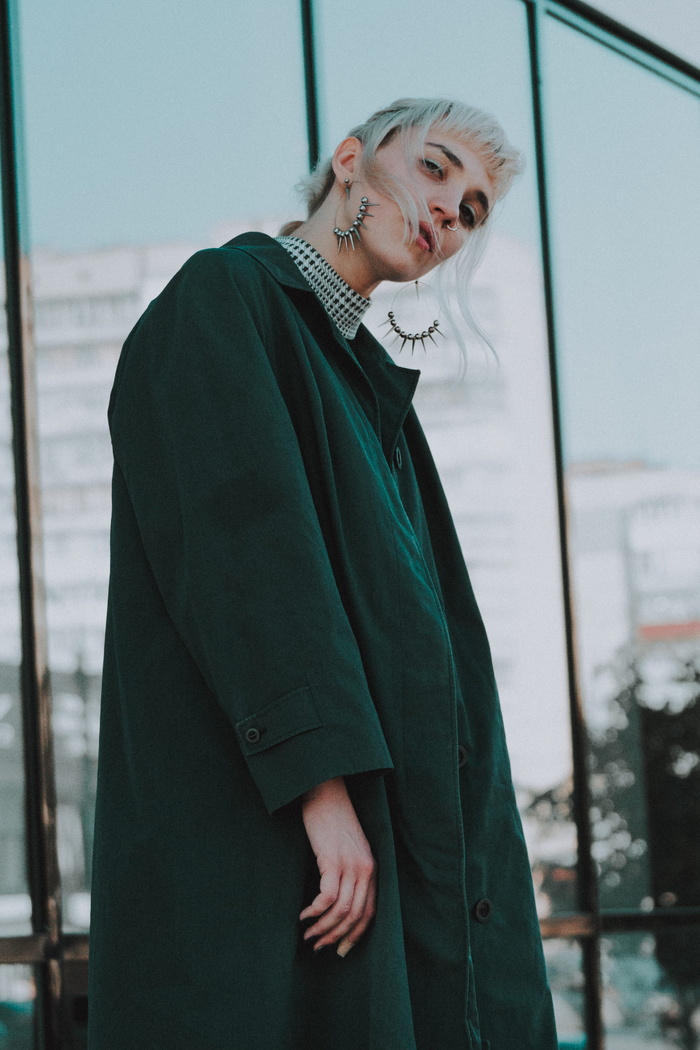 一名身穿黑色外套的妇女站在透明的玻璃墙附近
