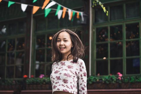 白天站在五彩旗下微笑的女人