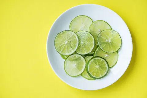 茶碟上的酸橙水果照片