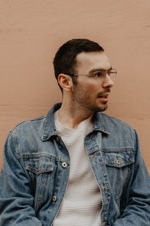 身穿蓝色牛仔夹克的男子凝视左侧