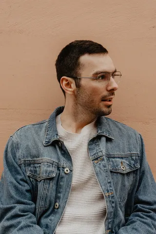 身穿蓝色牛仔夹克的男子凝视左侧