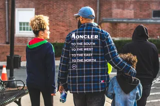 男子穿着蓝、白、黑格子连衣裙衬衫，露出背部