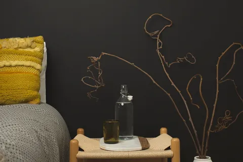 桌子上除了琥珀色的酒杯,还有一个透明的玻璃瓶 桌子上除了琥珀色的酒杯,还有一个透明的玻璃瓶