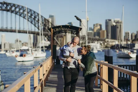 男女老少抱着婴儿在木码头上行走