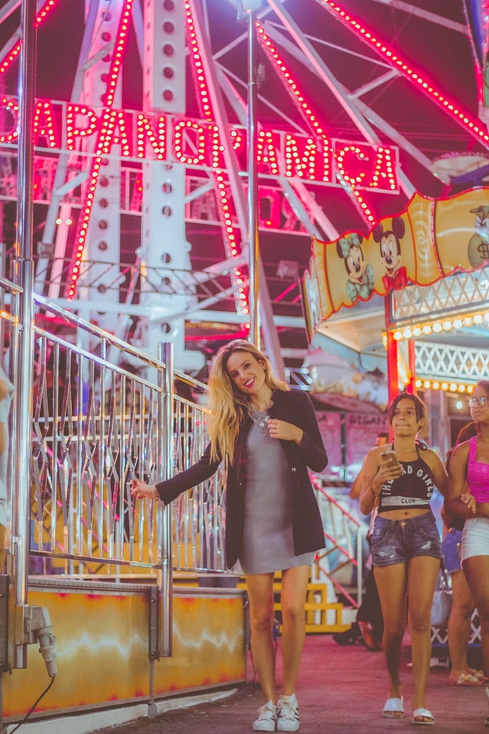 身穿黑色外套的女子站在摩天轮附近