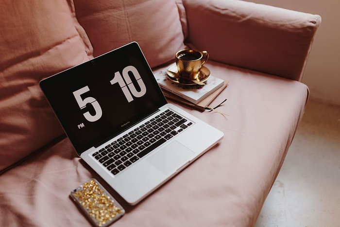 在粉色沙发上放着笔记本电脑的工作场所