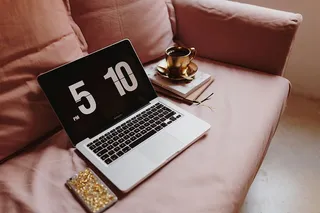 在粉色沙发上放着笔记本电脑的工作场所