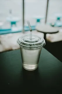 在黑色表面顶部放置透明塑料一次性杯子 在黑色表面顶部放置透明塑料一次性杯子