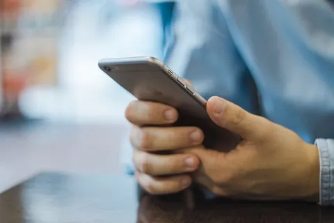 拿着灰色Iphone 6的人 拿着灰色Iphone 6的人