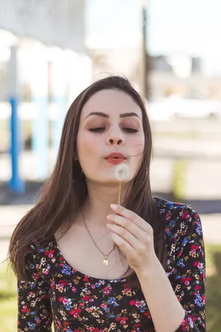 吹蒲公英花的女人