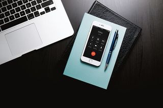 商人的办公桌，配有笔记本电脑、电话、日记和记事本