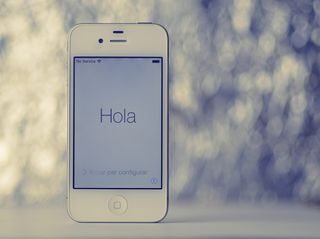 打开白色iPhone 4，显示Hola文字问候语