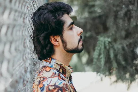 一名男子身穿棕色衣领，上衣有纽扣