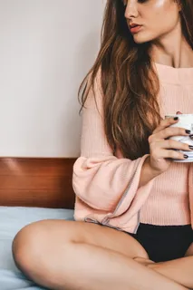 坐在床上拿着杯子的女人 坐在床上拿着杯子的女人