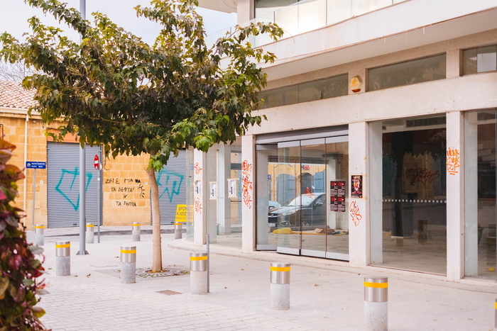 绿叶树和混凝土柱附近的灰色混凝土建筑