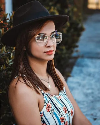 身穿白色和蓝色条纹印花背心裙和黑色帽子的女士