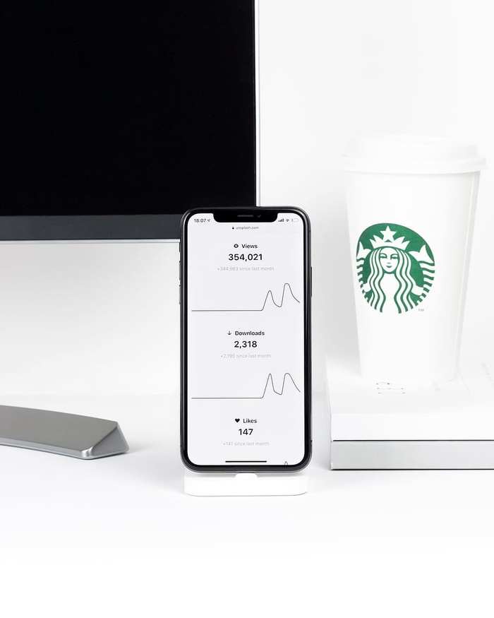 桌上星巴克一次性杯子旁边的iPhone X