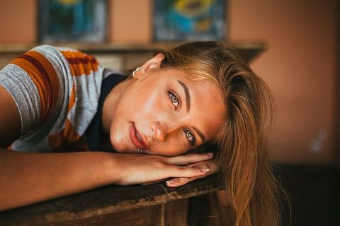 一张女人的脸靠在棕色表面的特写照片