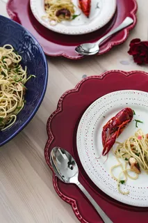 精美的晚餐,搭配海鲜意大利面、小龙虾和红酒,餐桌上装饰着玫瑰 精美的晚餐,搭配海鲜意大利面、小龙虾和红酒,餐桌上装饰着玫瑰