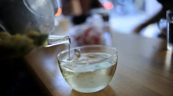 在透明玻璃杯上倒入液体的透明玻璃罐 在透明玻璃杯上倒入液体的透明玻璃罐