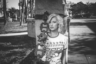 女性靠在灰色混凝土柱上的灰度照片