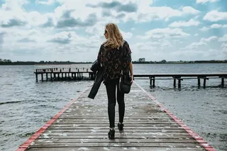 湖边一个木码头上美丽的金发女人