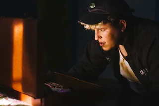 男子站在棕色皮箱前特写照片