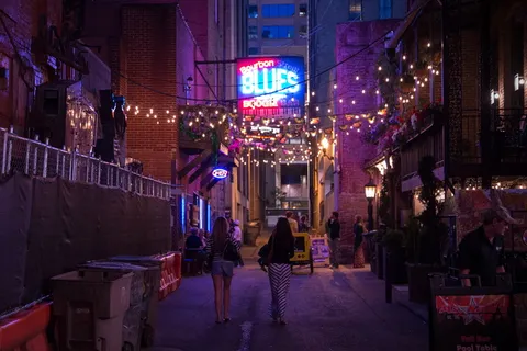 人们在灯光下穿过市中心的街道。 人们在灯光下穿过市中心的街道。