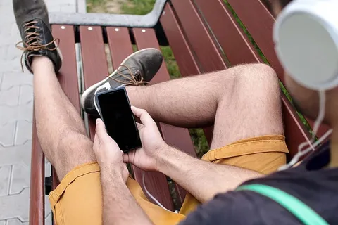 坐在长椅上欣赏音乐的年轻人 坐在长椅上欣赏音乐的年轻人